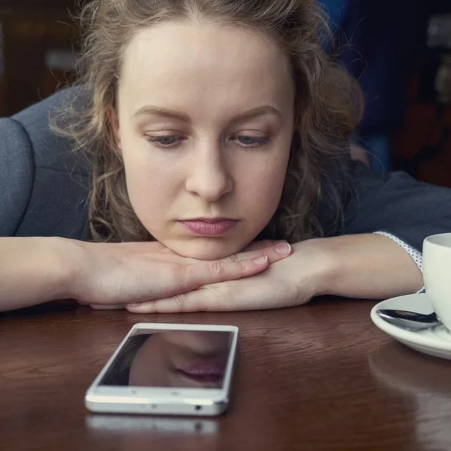 A client sitting by her phone, waiting for her lawyer to call her back.