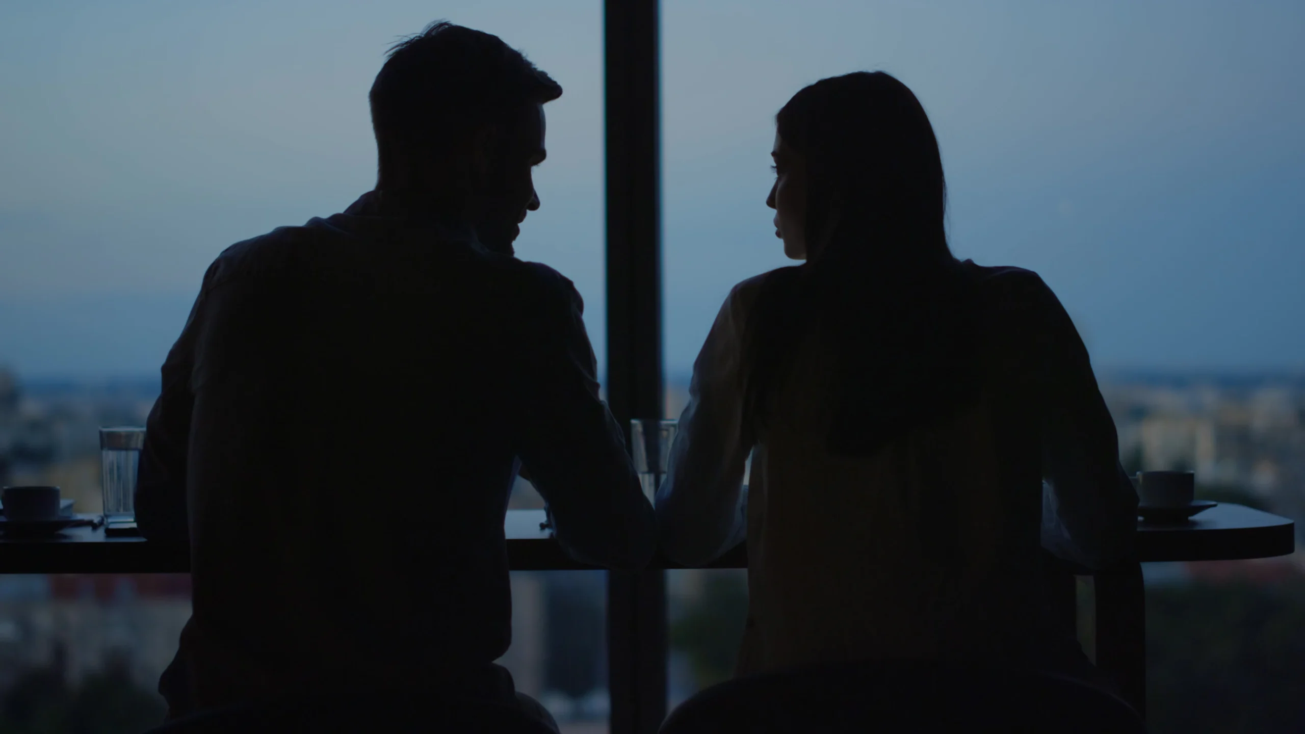 Two people talking in a dark room in silhouette. Secret meeting that may constitute a conflict of interest.