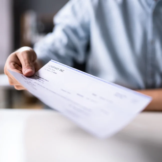 Attorney handing their client a settlement check.