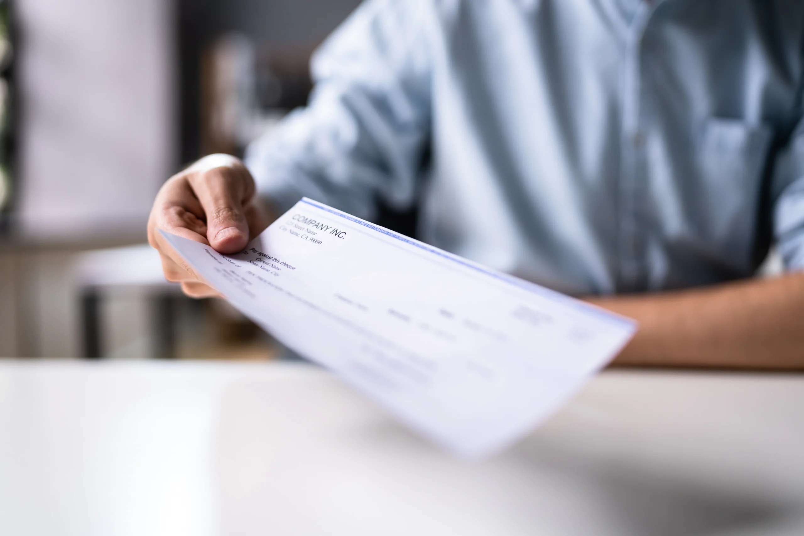 Attorney handing their client a settlement check.