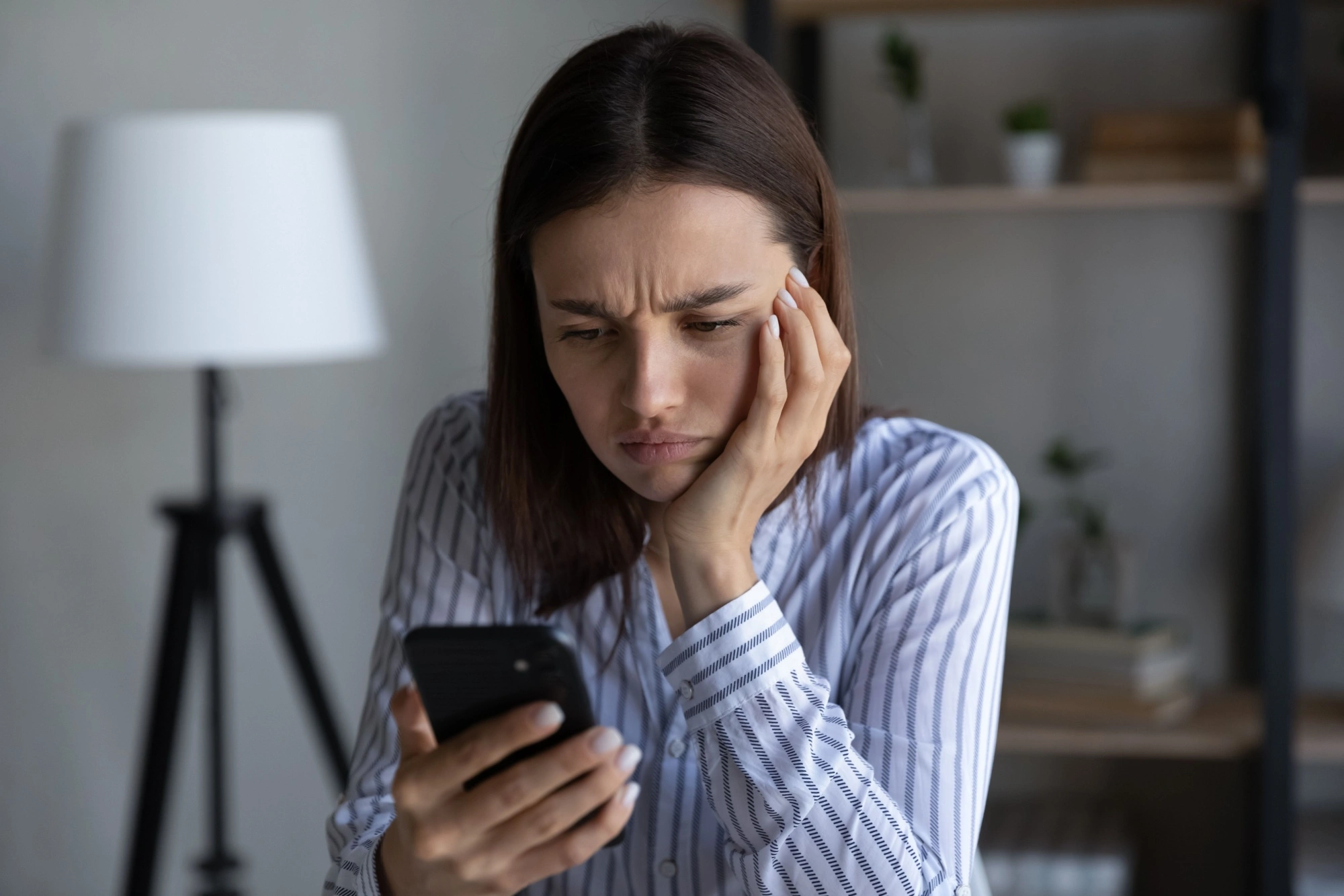 Professional woman looking at her phone angrily