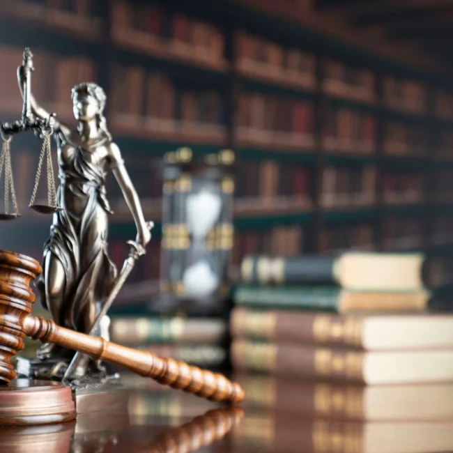 Gavel on a bench in front of a legal statue